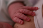 Vauvan käsi rinnalla