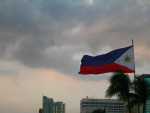 Filippiinien lippu liehuu pilvistä taivasta vasten
