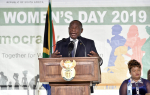 Etelä-Afrikan presidentti Cyril Ramaphosa taustallaan naisten päivän juliste