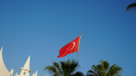 Turkin lippu, palmujen latvoja ja rakennuksen tornit