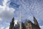 YK-lippu liehuu vanhan rakennuksen edustalla.