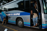 Salvadorilaisia pakolaisia astuu bussista ulos peitetyin kasvoin.