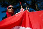 Tunisialainen nainen pitää Tunisian lippua kädessä.