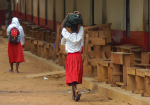 Kaksi tyttöä koululaukkujen kanssa Keniassa