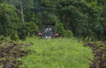 Nicaragualainen viljelijä ajaa traktorilla pellolla.