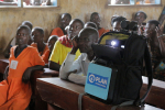 Kyläläiset katsovat koulutusvideota mediarepun välityksellä Ugandassa