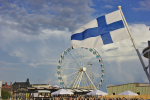 Suomen lippu ja Helsingin Kauppatorin maailmanpyörä.