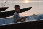 Poika ja veneitä Mekong-joella Laosissa