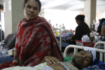 Potilas sairaalasängyssä ja omainen Nepalissa
