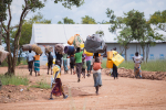 Pakolaisia saapumassa Ugandaan, taustalla vastaanottokeskus