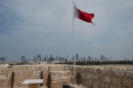 Bahrainin lippu, taustalla pääkaupunki Manaman rakennuksia