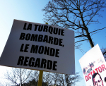 Ranskankielinen "Turkki pommittaa, maailma katselee" -kyltti