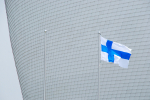 Suomen lippu ison rakennuksen edustalla