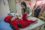 Fysioterapeutti auttaa lasta Irakissa