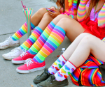 Sateenkaaren värisiin sukkiin pukeutuneiden ihmisten jalkoja
