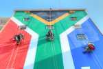 Etelä-Afrikan lipun väreihin maalattu talo ja kiipeilijöitä