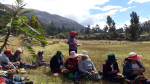 Perulaisia naisia ja miehiä syömässä ulkona vuoristossa