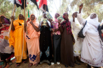 Sudanilaisia naisia lippuja ja kirjoja käsissään