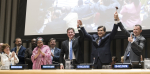 YK:n siirtolaisuussopimuksen neuvottelijoita kädet ylhäällä