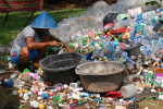 Aasialainen mies lajittelee muovijätettä