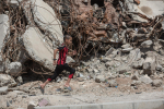 Poika juoksemassa tuhoutuneen talon ohi Länsi-Mosulissa heinäkuussa 2018 .