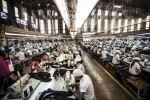 Työntekijöitä ompelukoneilla tehtaassa
