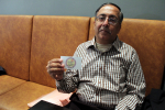 Intialainen Harish Sadani näyttää MAVA-järjestön käyntikorttiaan
