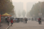 Joukko ihmisiä kadulla Kiinassa, saasteet hämärtävät näkymää