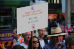 Mielenosoittajia Australiassa "People who are seeking asylum are welcome in my home" -kyltin kera