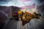 Nainen ja lapsi malariaverkon alla