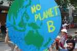 Mielenosoittajia maapallon muotoisen No Planet B -tekstillä varustetun kyltin kanssa