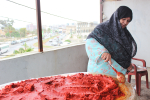 Palestiinalaispakolainen sekoittamassa punaista maustetta