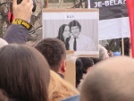 Valokuvakyltti pariskunnasta mielenosoittajien keskellä
