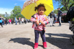 Pikkutyttö keltaisen sateenvarjon alla
