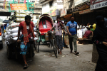 Miehet vetävät kärryjä kadulla Bangladeshin pääkaupungissa Dhakassa