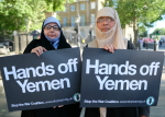 Kaksi mielenosoittajaa Hands off Jemen -kylttien kera