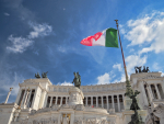 Italian lippu valkoisen rakennuksen edessä