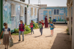 Koulutyttöjen reppujen kera pakolaisleirillä