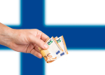 KÄsi pitelee 50 euron seteliä, taustalla Suomen lippu