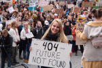 Nuori nainen pitelee ilmastomielenosoituksessa kylttiä "Future not Found"
