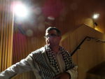 Mies palestiinalaishuivi olkapäillään