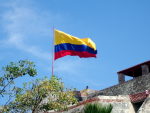 Kolumbian lippu ja talojen raunioita
