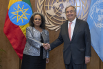 Etiopian presidentti ja YK:n pääsihteeri kättelevät, taustalla Etiopian lippu ja YK:n logo