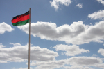 Musta-puna-vihreä Malawin lippu taivasta ja pilviä vasten.