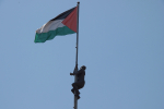 Palestiinan lippu, jota pitkin kiipeää patsas.