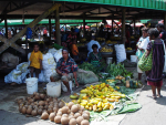 Naisia ja lapsia torilla myymässä mangoja ja kookospähkinöitä.