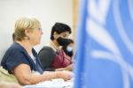 Kaksi naista sivulta otetussa kuvassa, etualalla osa YK:n lipusta.
