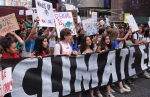 Nuoria mielenosoituskyltit käsissä, alla banneri, jossa lukee Climate.