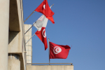 Puna-valkoisia Tunisian lippuja rakennuksen seinässä.