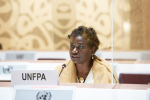 Nainen pöydän takana istumassa, edessä kyltti UNFPA.